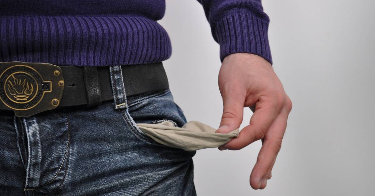 Mano sacando el bolsillo vacío de jeans